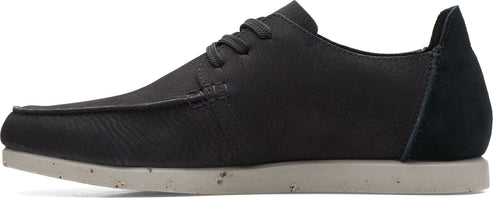 A dark colored casual shoe with laces and light colored sole.