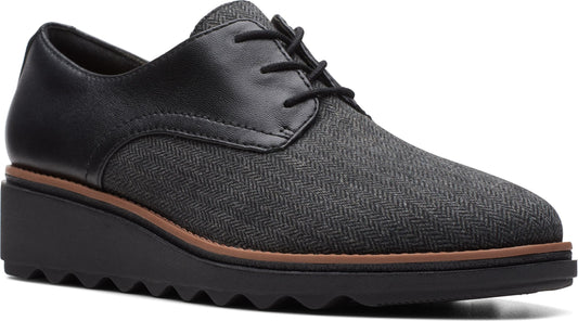 A gray herringbone lace-up platform shoe with black leather trim.