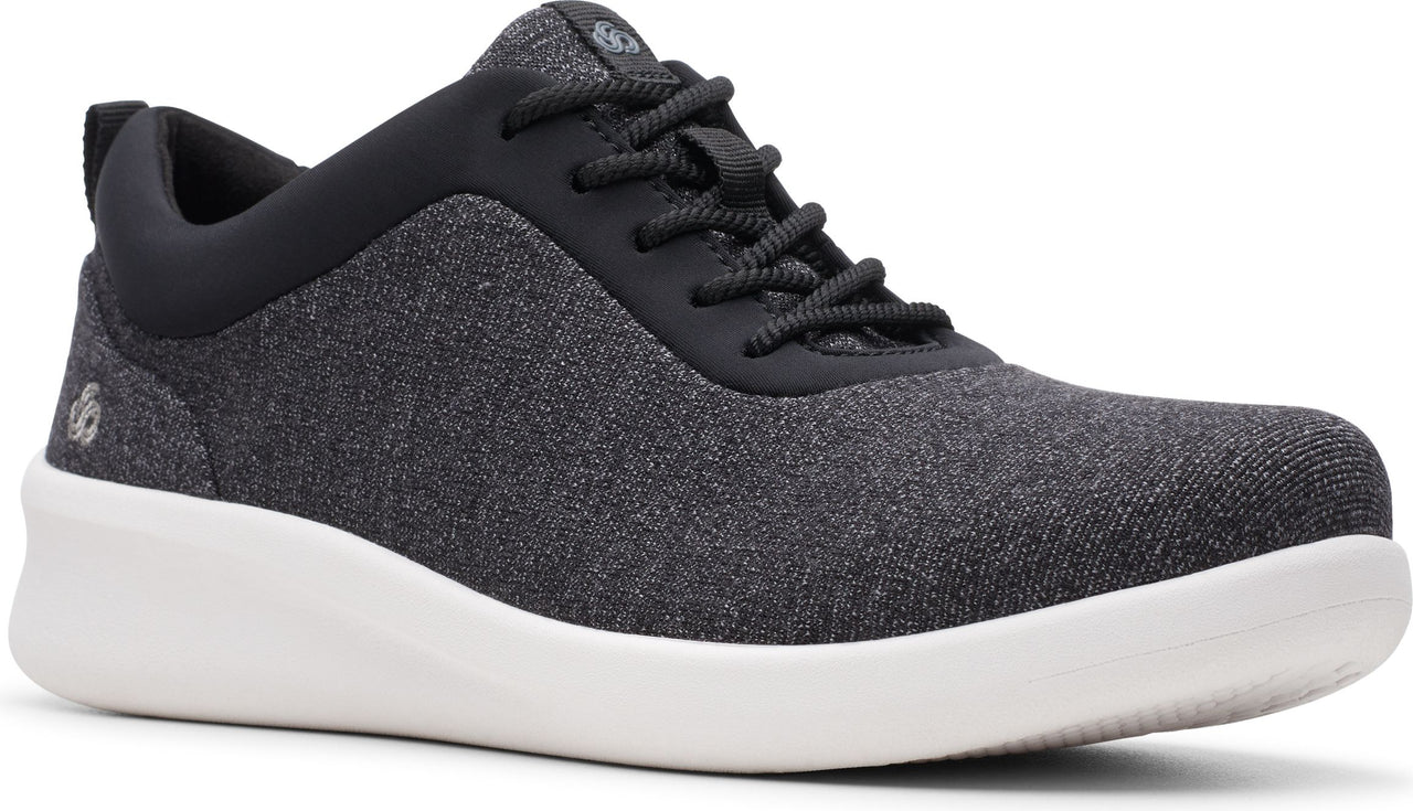 Low-top athletic shoe, black upper, black laces, black collar, white sole.