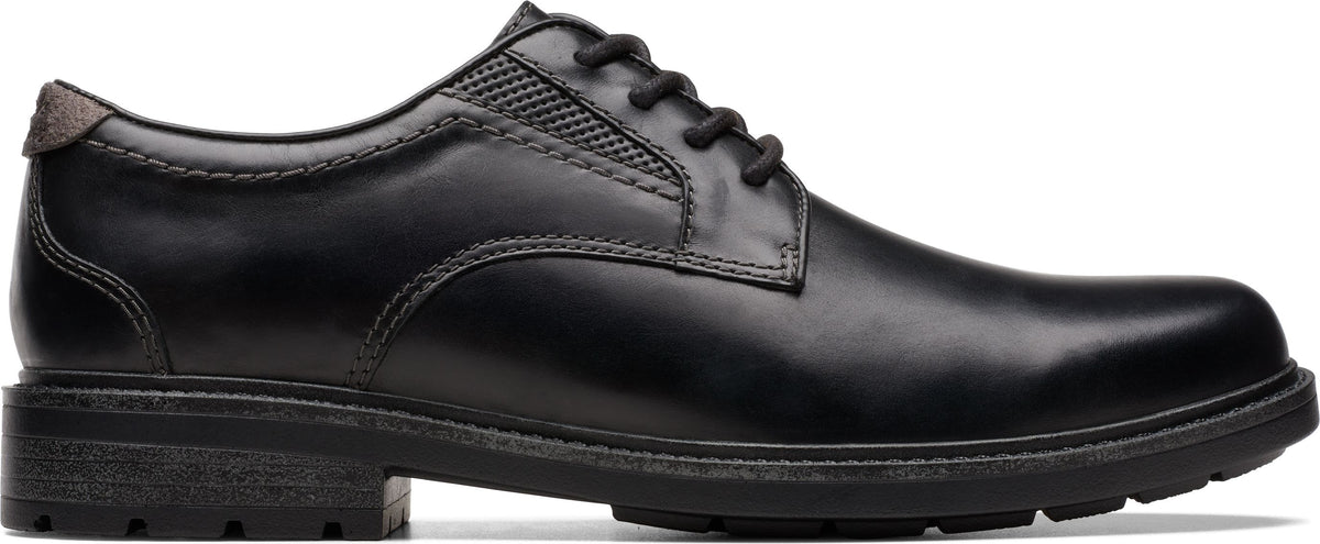 A black leather lace-up dress shoe with a lug sole.