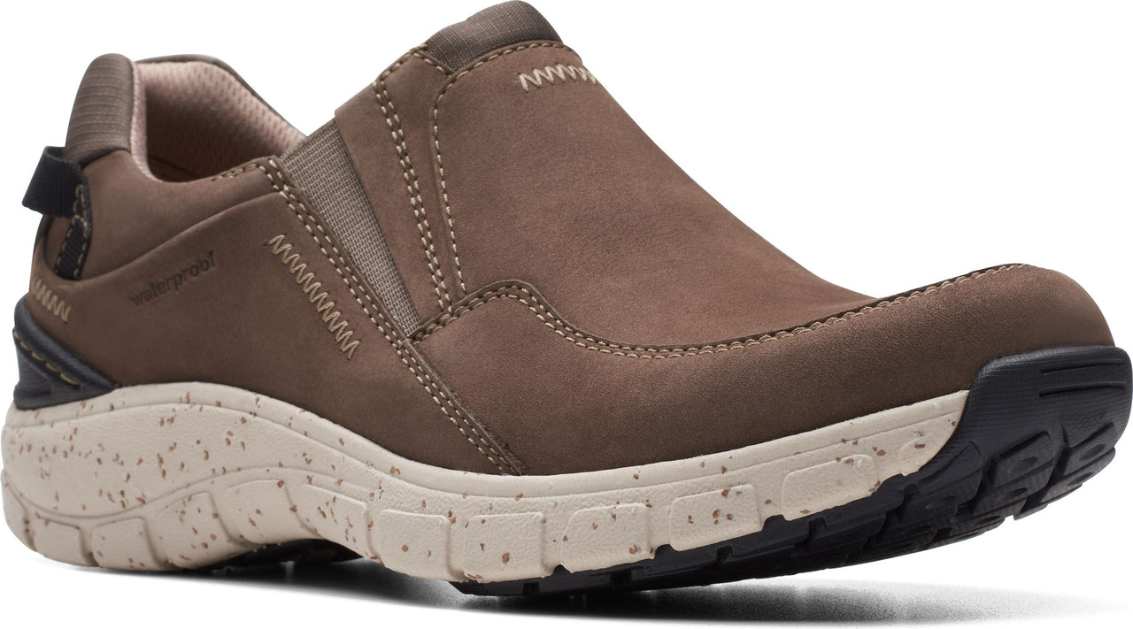 Slip-on brown leather shoe with elastic side panels and thick speckled beige and black sole.