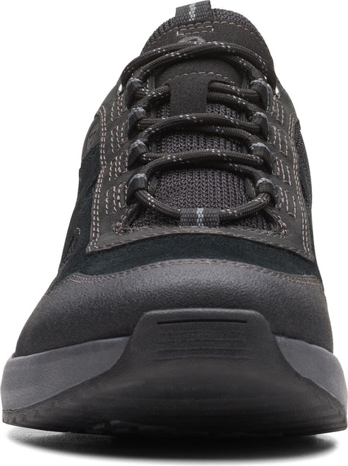 Close-up of a black sneaker with a lace-up closure and a thick, dark sole.