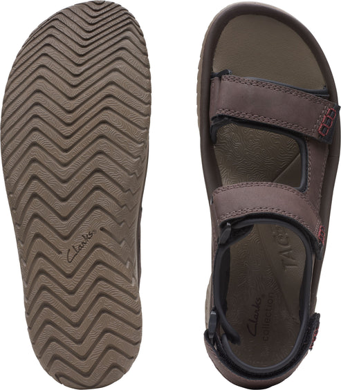 A pair of sandals: one showing the zigzag patterned brown sole, and the other showing the top view with multiple hook-and-loop straps and the text "TAG" and "Clarks Collection" visible on the insole.