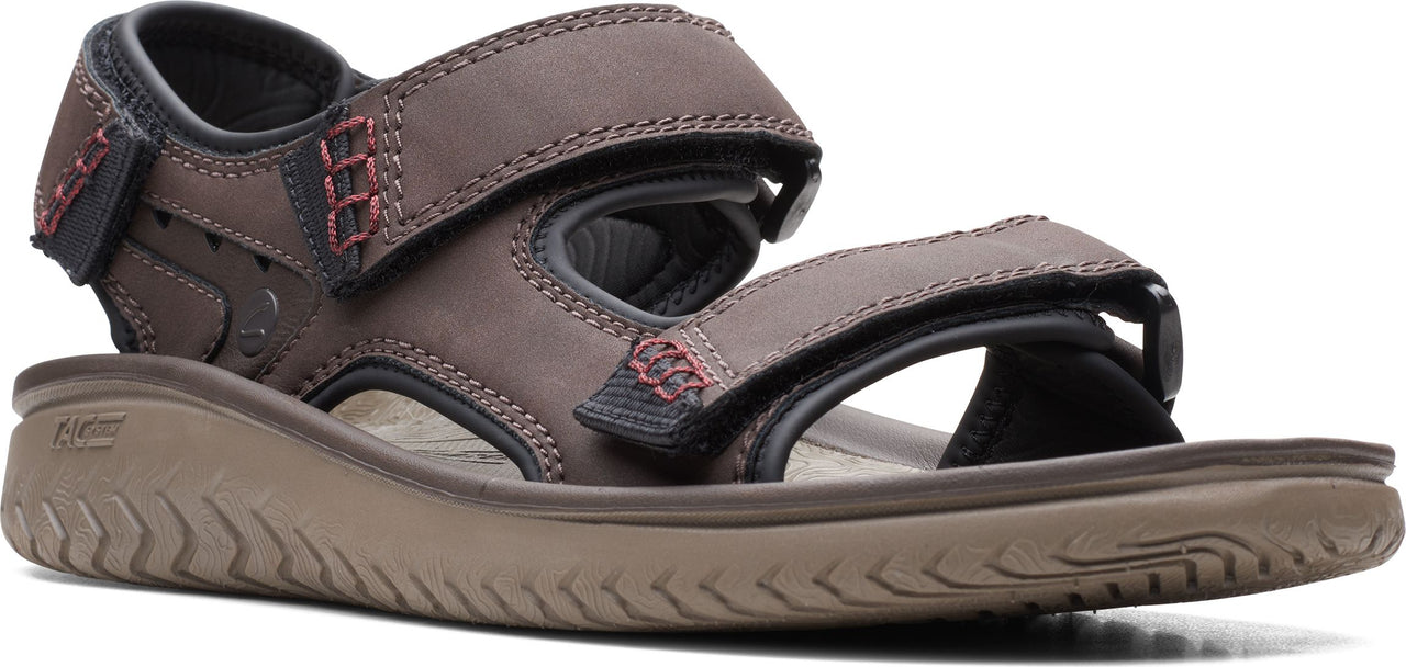 A brown sandal with hook-and-loop straps and red accent stitching.