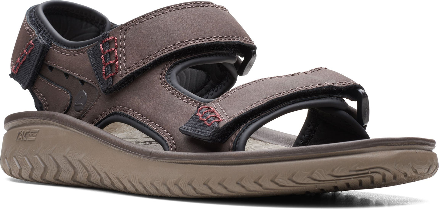 A brown sandal with hook-and-loop straps and red accent stitching.