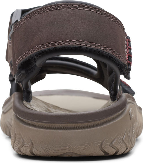 Rear view of a brown sandal with thick tan sole and hook and loop fastener.