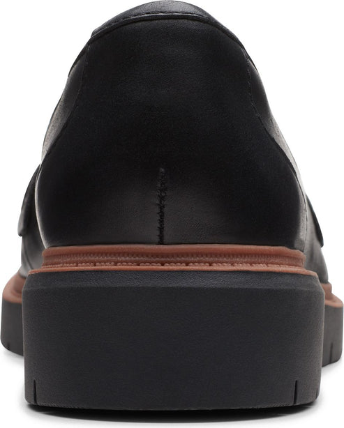 Close-up back view of a black leather platform slip-on shoe.