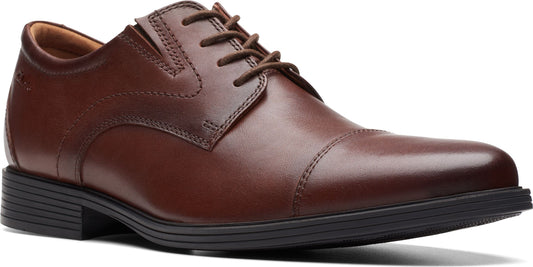 A brown leather dress shoe with black sole.