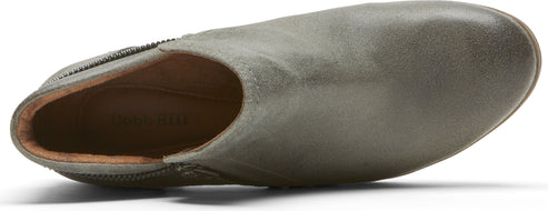 A close-up of a sage green mule shoe, showing its upper material and interior.