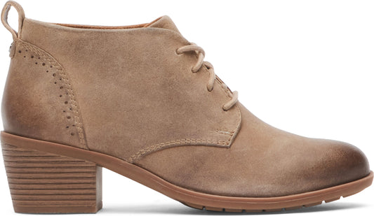 A beige suede heeled ankle boot with laces and a rounded toe.