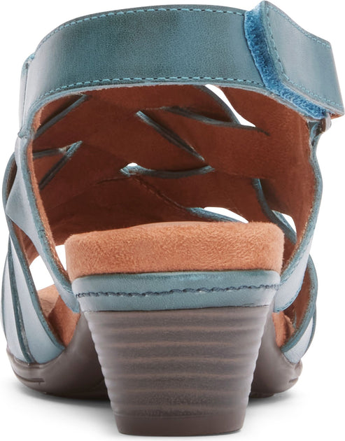 Turquoise sandal with a low, stacked heel and adjustable velcro closure at the ankle strap, showcasing an open, woven design.