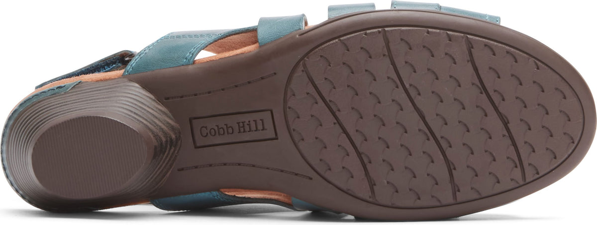 Blue sandal with a brown sole that shows the brand name Cobb Hill.