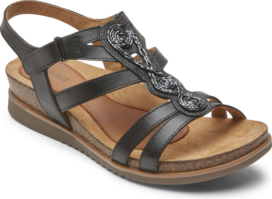 Black sandal with decorative embellishments, straps, and a wedge heel.