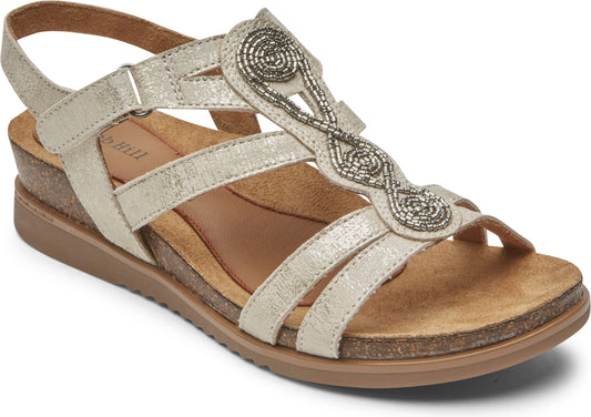 Flat sandal with tan sole, faux cork wedge heel, metallic straps, and bead embellishments.