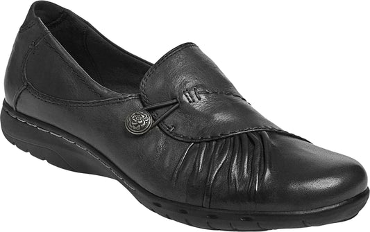 Black leather slip-on shoe with gathered toe, decorative button, and low wedge heel.