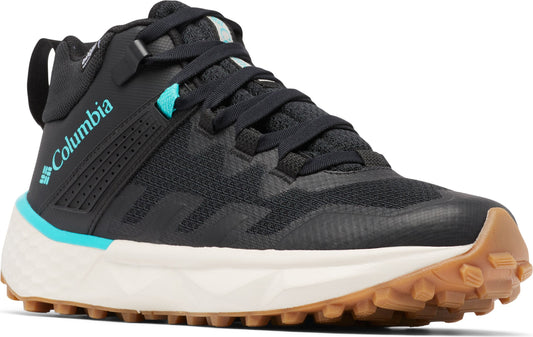 A black mid-height sneaker with blue accents and Columbia written on the side, has a white midsole and brown treaded outsole.