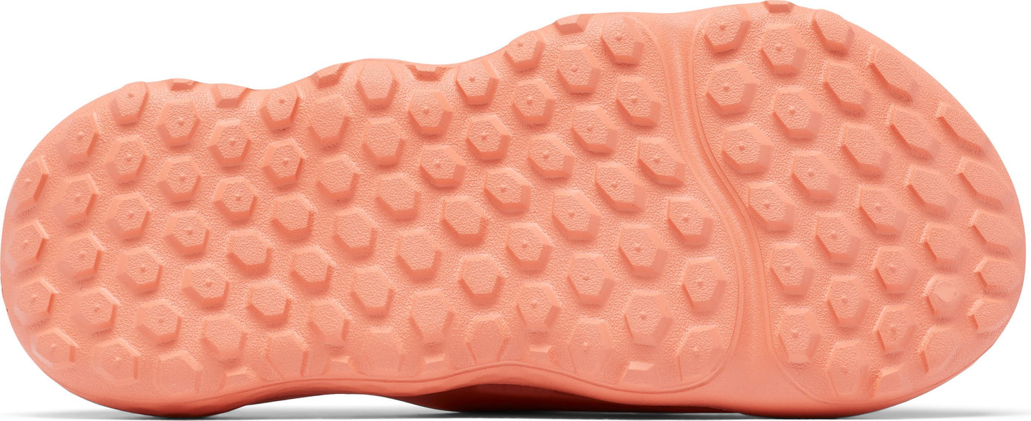 Bottom view of a pink shoe with a textured sole featuring hexagonal patterns.