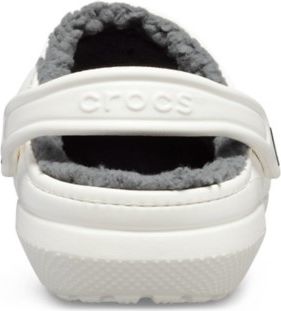 White shoe with gray furry inner lining and back strap displaying the word 'crocs'.