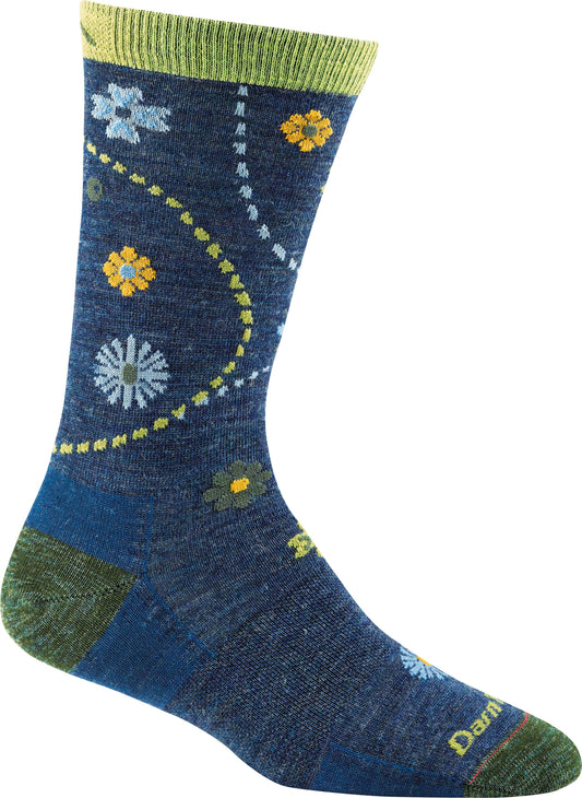 A blue sock with green toe and heel that features a variety of floral designs in yellow and blue, plus a white and green dotted line.