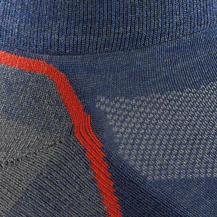 Close up of a blue-grey sock with a diagonal red stripe and a ventilated pattern.