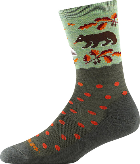 A crew sock, top band with a brown bear in an outdoor scene, below a dark green fabric with red dots, ending in a dark green toe.