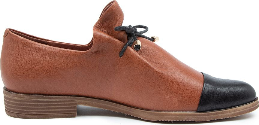A brown leather shoe with a black toe and a brown stacked heel.