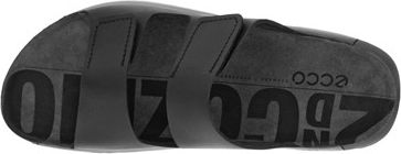 A black sandal with velcro straps and large text on the sole.