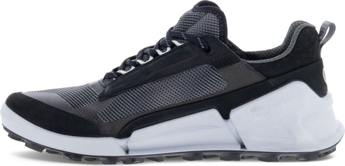 A low-rise athletic shoe with a black-and-grey upper and a thick white midsole.