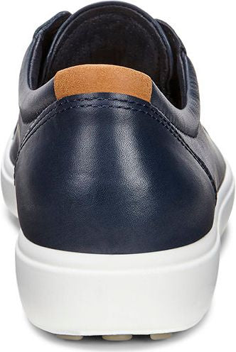 Back view of a navy blue leather sneaker with white sole and brown suede heel tab.