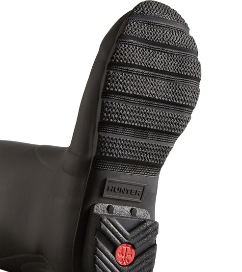 Close-up of the sole of a rubber boot featuring horizontal treads and a Hunter logo.