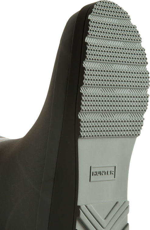 Close-up of the gray sole of a black boot with the text "HUNTER" and a textured bottom.