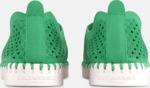 Two green shoes with intricate laser-cut patterns and white soles.
