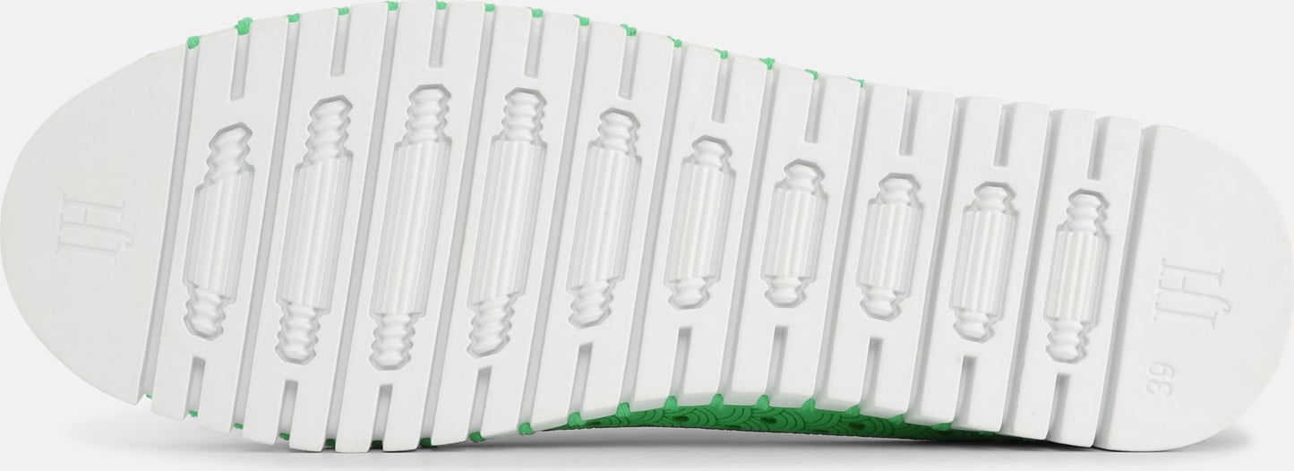 Close-up of a shoe sole with a white ridged pattern and oblong cutouts.