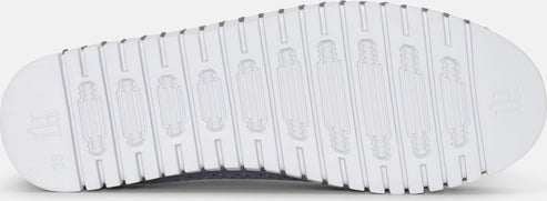 Close-up of a white shoe sole with ridged texture.