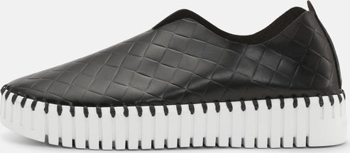 Black slip-on shoe with a white ridged sole.