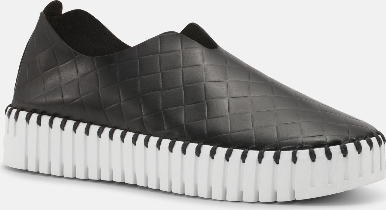 Black slip-on loafer with textured square pattern and thick white grooved sole.