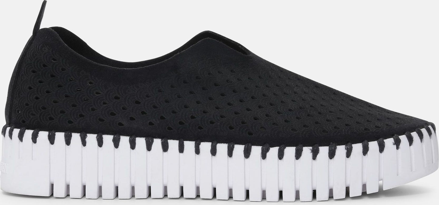 Black slip-on shoe with perforated knit upper and white lug sole.