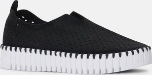 A black slip-on shoe with a thick white sole.