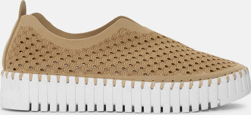 A tan slip-on shoe featuring a geometric pattern on the upper and a segmented white sole.