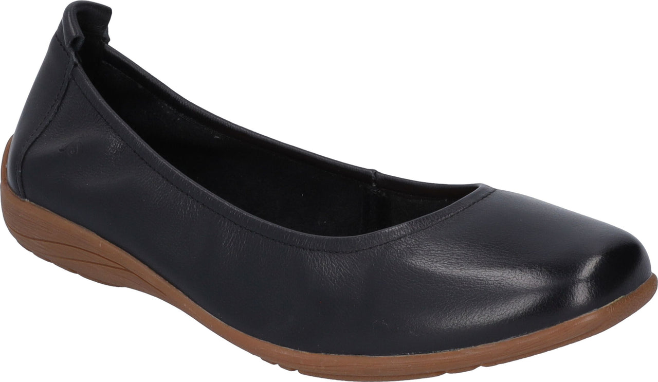 Black leather ballet flat with elasticized heel on a low brown wedge.