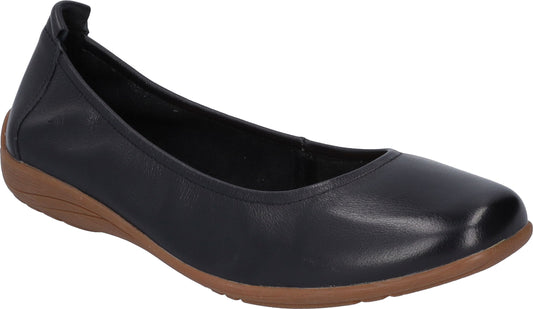 Black leather ballet flat with elasticized heel on a low brown wedge.