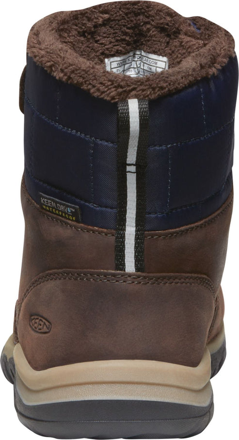 Back view of a waterproof brown leather boot with navy fabric, a velcro strap, and a brown faux fur trim.