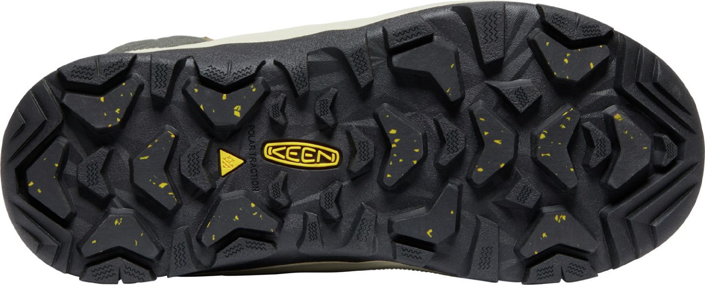 A close-up of a shoe's sole with a KEEN logo at the center, showing a black, heavily-lugged tread interspersed with yellow flecks.
