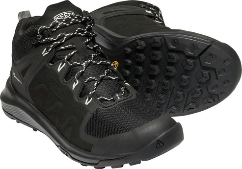 Black hiking boot with white and black laces and rugged sole.
