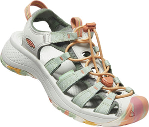 A sandal with a light gray footbed and white sole, adjustable peach cord laces, and light green straps.