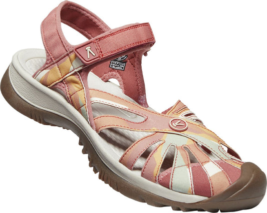A pink sandal with velcro strap, rubber toe cap, and floral pattern.