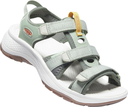 Angled view of a pale green sandal with velcro straps, white sole and brown rubber tread.