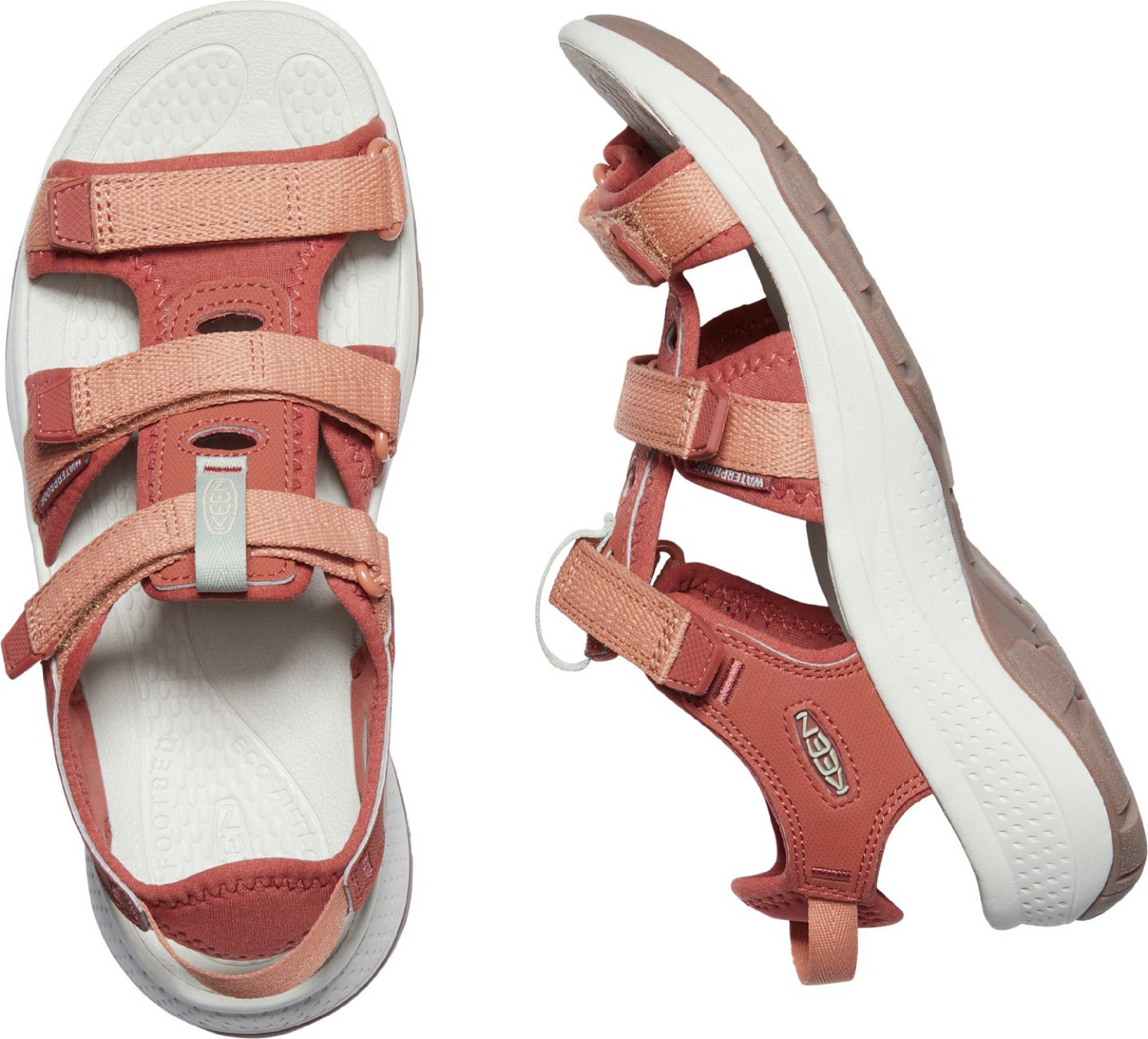 Two salmon-colored sandals, one showing the sole which is white with a gray outline.