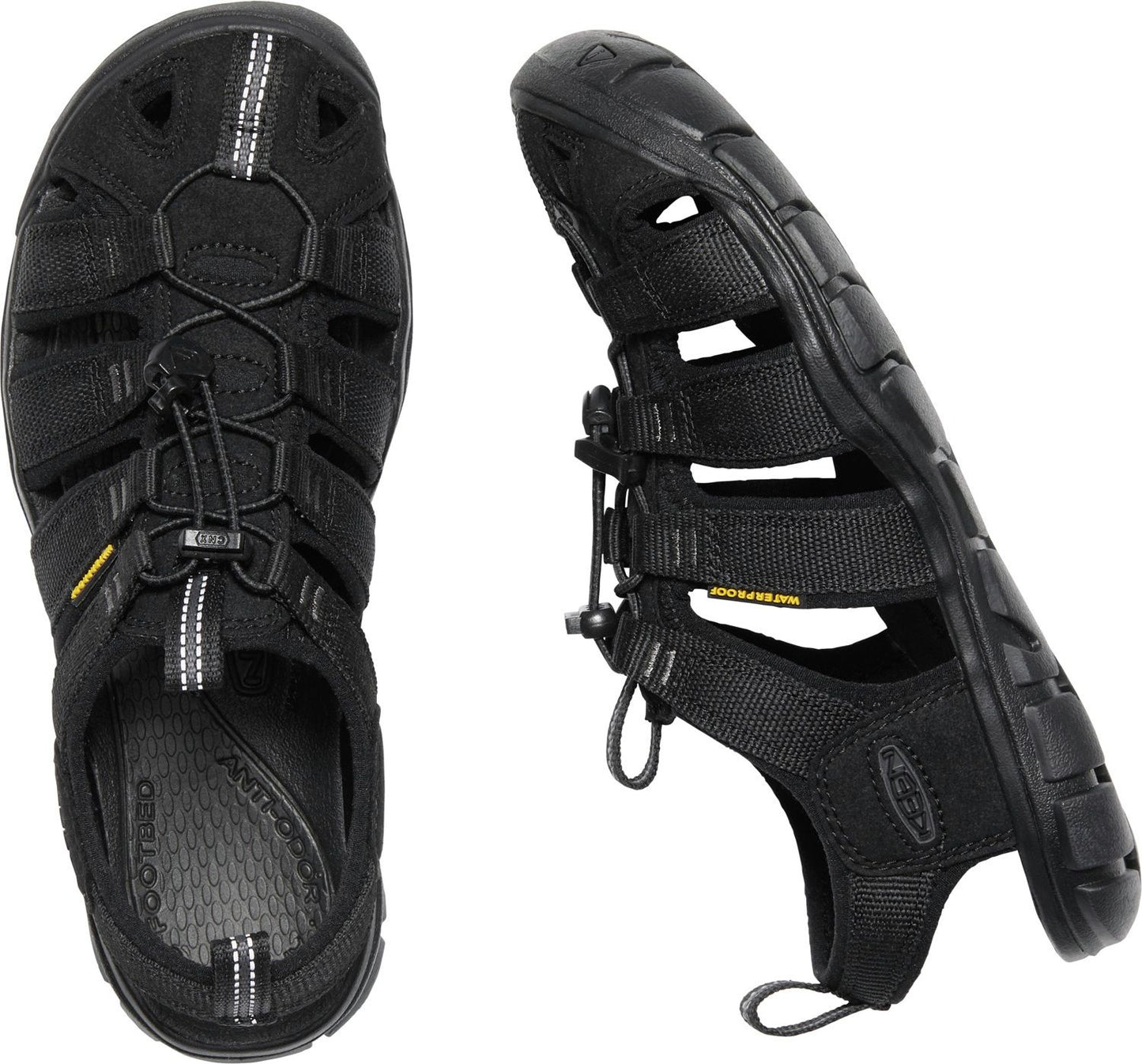 A pair of black sandals with an intricate webbing design and bungee cord lacing.