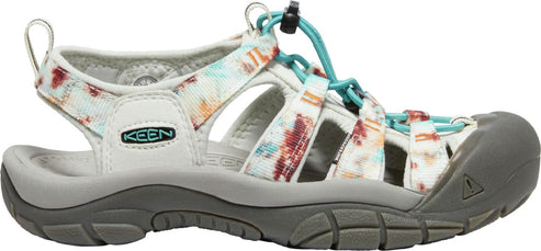 Low profile sandal with a grey sole, toe guard, and a white strap with red and blue floral patterns.